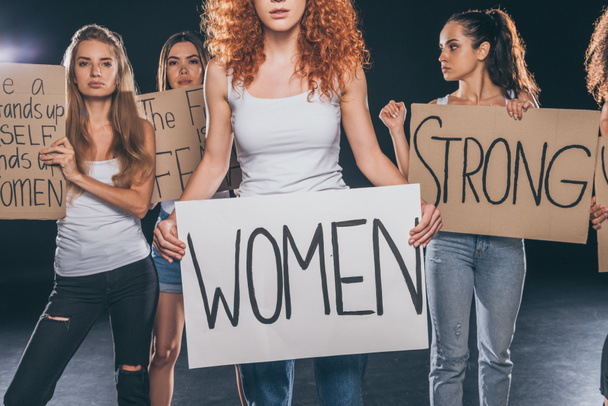 young women standing and holding placards with lettering on black   - Foto, afbeelding
