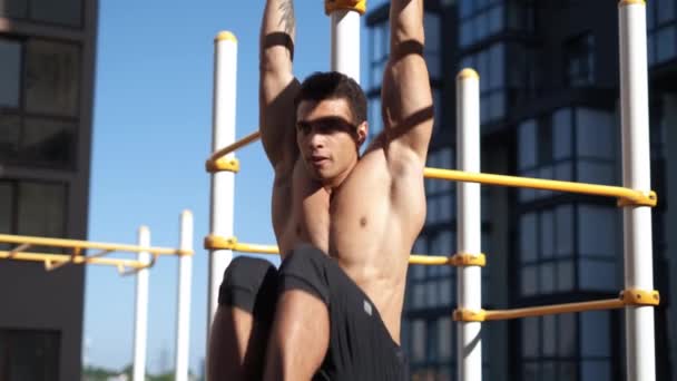 Young muscular man has the training outdoors. Sport, fitness, street workout concept. - Video, Çekim