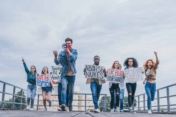 personas emocionales multiculturales con letras en carteles corriendo afuera
  - Foto, Imagen