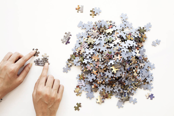 Person reicht unfertige farbige Puzzleteile auf weißem Hintergrund. Geschäftskonzept - Foto, Bild