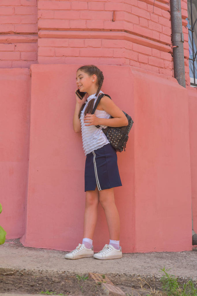 close up πορτρέτο του μικρό όμορφο κομψό παιδί κορίτσι κοντά στο κόκκινο τοίχο ως φόντο - Φωτογραφία, εικόνα