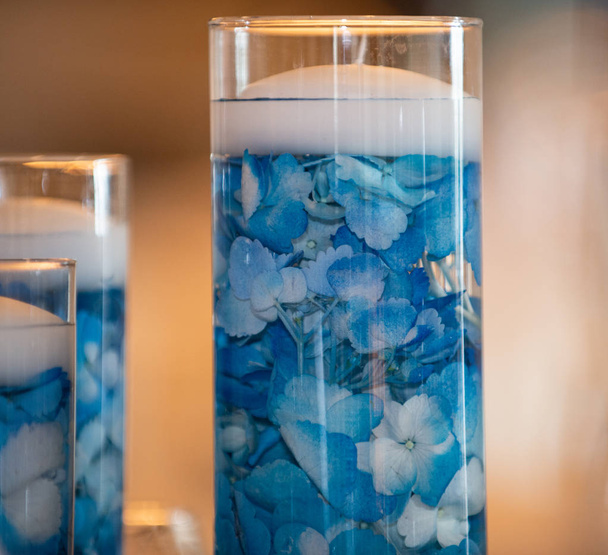 Floating candle centerpiece with blue flower pedals close up - Photo, Image