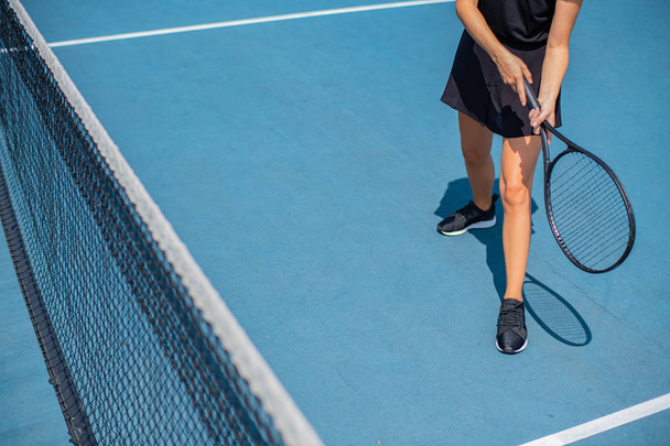 Jovem desportista a jogar ténis no campo de ténis azul
 - Foto, Imagem