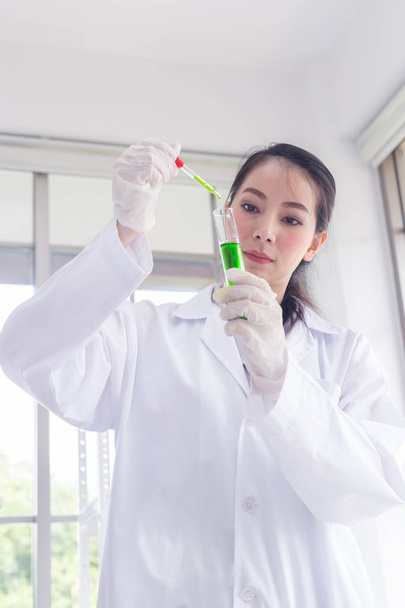 Aziatische vrouwen wetenschapper het uitvoeren van onderzoek in een chemie lab. - Foto, afbeelding
