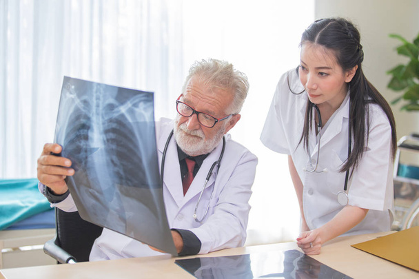 Senior male doctor is giving women doctor visiting radiologist f - Foto, Imagen