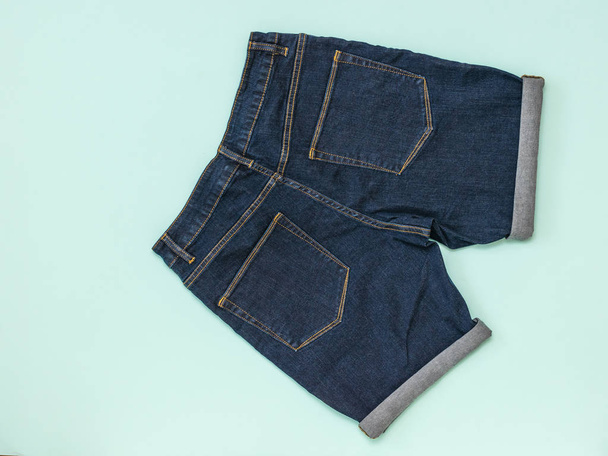 Pantalones cortos de mezclilla azul sobre fondo azul. Ropa unisex de moda
. - Foto, imagen
