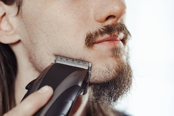 facet goli swoją brodę z elektrycznym brzytwa - Zdjęcie, obraz