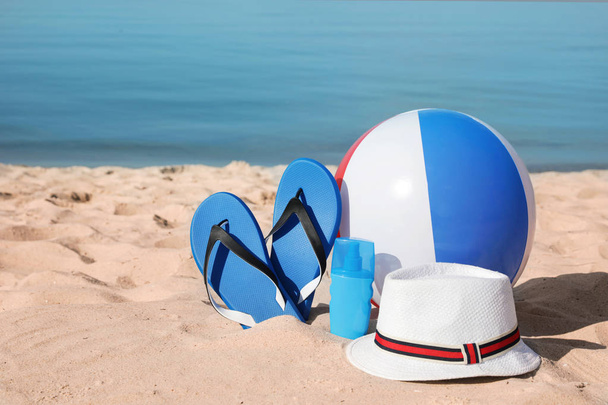 Пляжные аксессуары на песке у моря. Пространство для текста
 - Фото, изображение