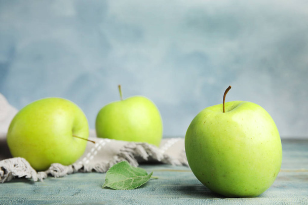 Fresh ripe green apples on wooden table against blue background, space for text - Φωτογραφία, εικόνα