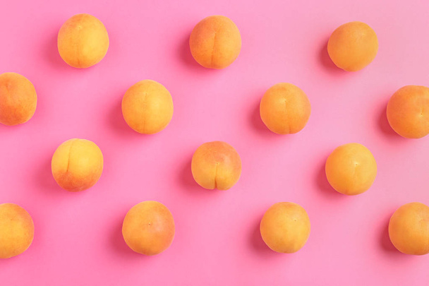 Delicious ripe sweet apricots on pink background, flat lay - Foto, immagini