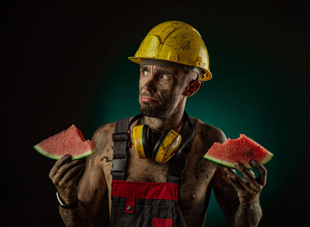 昼食にスイカを食べる幸せな笑顔の鉱夫の肖像 - 写真・画像