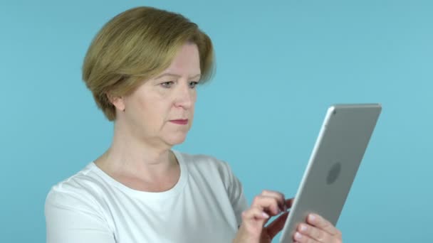 Стара жінка реагує на втрату на планшеті ізольовані на синьому фоні - Кадри, відео