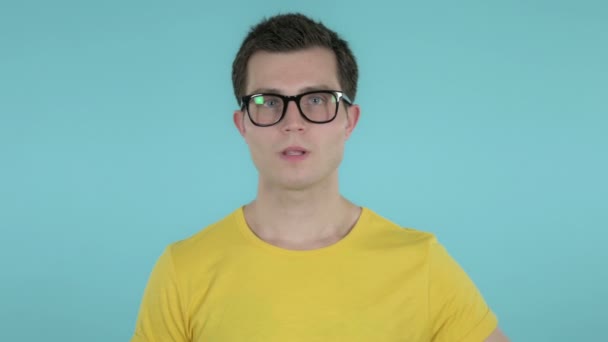 Genç Adam Gesturing Thumbs Aşağı Mavi Arka Plan Üzerinde İzole - Video, Çekim