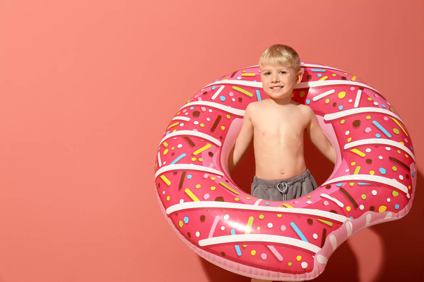 Cute little boy with inflatable ring on color background - Photo, Image