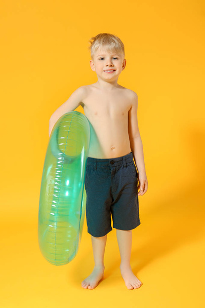 Cute little boy with inflatable ring on color background - Фото, зображення
