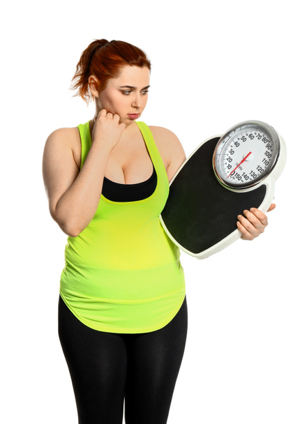 Overgewicht vrouw met schubben op witte achtergrond. Gewichtsverlies concept - Foto, afbeelding