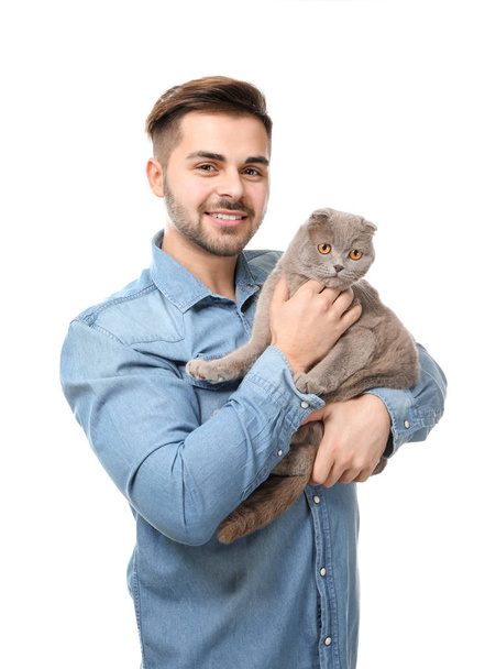 Young man with cute funny cat on white background - Photo, Image