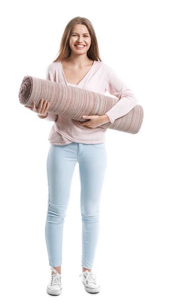 Jonge vrouw Holding gerold tapijt tegen witte achtergrond - Foto, afbeelding