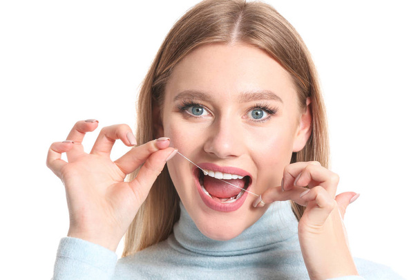 Mujer dientes de hilo dental sobre fondo blanco
 - Foto, imagen