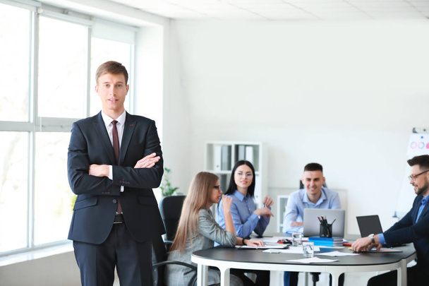 Бизнесмен с коллегами во время встречи в офисе
 - Фото, изображение