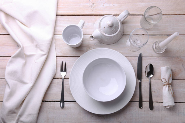 platos blancos, cubiertos, vasos y velas
  - Foto, imagen