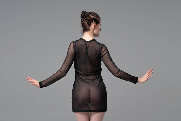 young beautiful girl posing in studio, standing in black transparent clothes - Foto, Bild