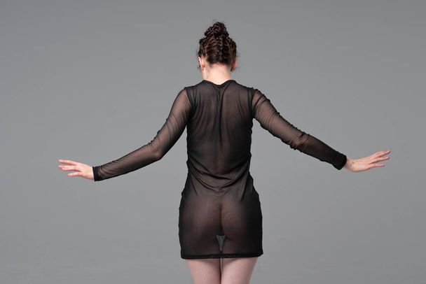 joven hermosa chica posando en estudio, de pie en negro transparente ropa
 - Foto, Imagen