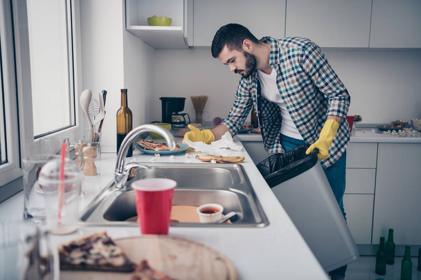 Portrait of his he nice attractive serious focused concentrated bearded guy wearing checked shirt doing domestic mess chaos maid in modern light white interior style kitchen indoors - Foto, imagen