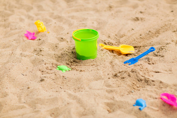 vödör és homok játékok a strandon vagy a homokozó - Fotó, kép