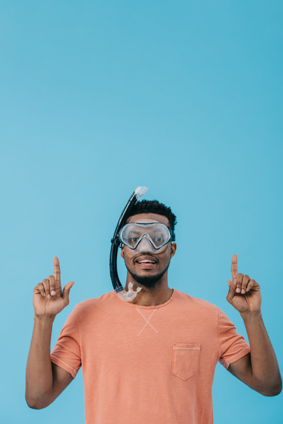 hombre americano africano alegre en la máscara de buceo señalando con los dedos aislados en azul
  - Foto, Imagen