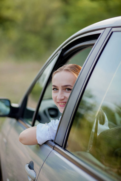 Portrait shot through windshield of pretty woman in car - Zdjęcie, obraz