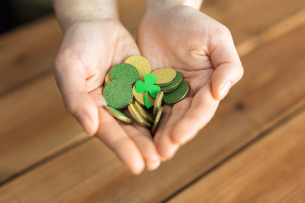 hands with golden coins and shamrock leaf - Foto, immagini