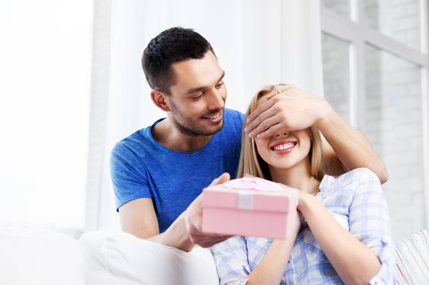 happy couple with gift box at home - Zdjęcie, obraz