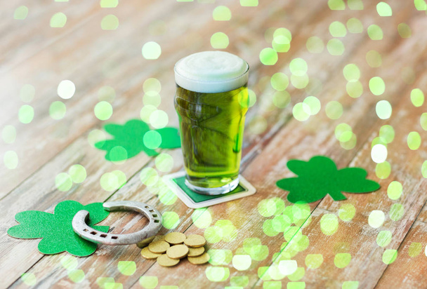glass of green beer, horseshoe and gold coins - Foto, Bild