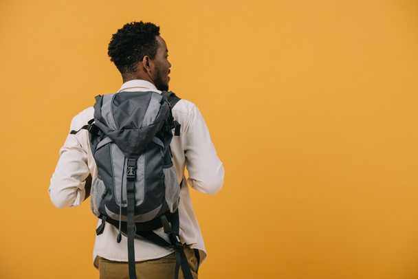 african american man standing with backpack isolated on orange - Foto, Imagem
