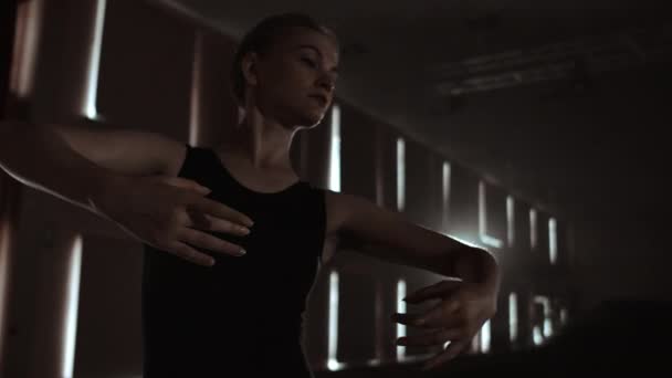 Κοντινό στάδιο της χορευτή μπαλέτου καθώς κάνει ασκήσεις σε σκοτεινή σκηνή ή στούντιο. Η μπαλαρίνα δείχνει κλασσικές μπαλέτο. Αργή κίνηση. Φωτοβολίδα, σουτ. - Πλάνα, βίντεο