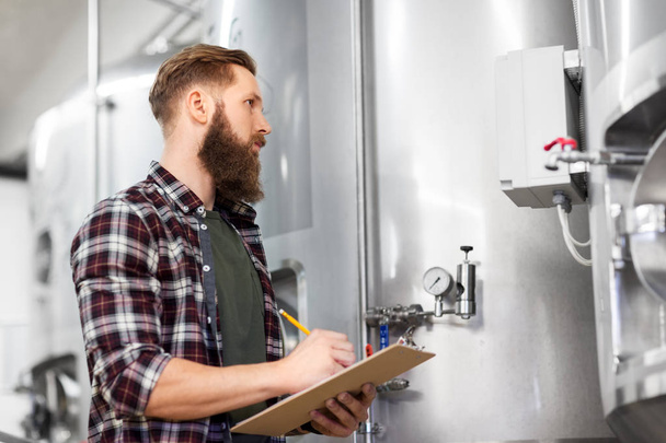 man with clipboard at craft brewery or beer plant - Photo, Image