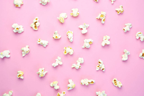 Popcorn lies evenly distributed on a colored surface - concept with a background consisting of popcorn which lies at a certain distance from each other on the surface  - Photo, Image