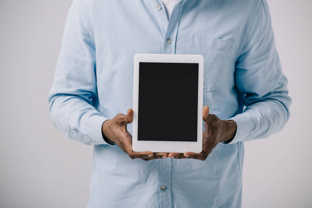 cropped view of african american man holding digital tablet with blank screen isolated on grey  - Foto, Bild