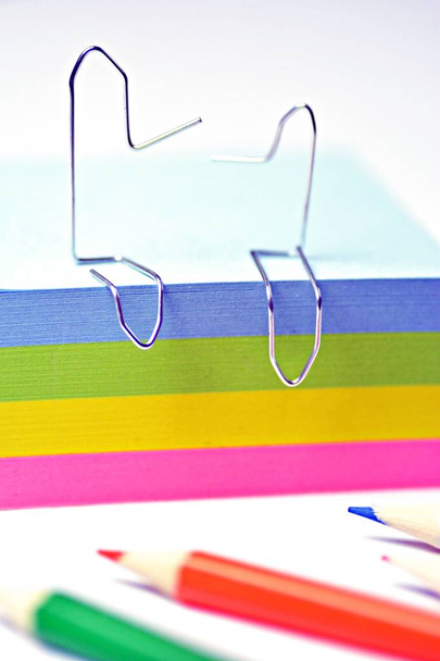 Twee paperclips aan man gebogen zitten op een hoop Sticky Notes en praat met elkaar-concept met paperclips en creatieve discussie in kantoor en professioneel leven - Foto, afbeelding