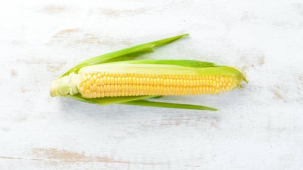 Fresh yellow corn on a white wooden background. Vegetables. Top view. Free copy space. - Foto, Imagen