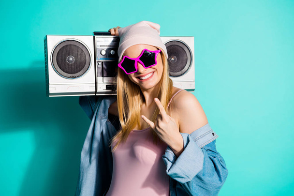 Portrait of nice attractive lovely cute cheerful cheery girl having fun showing horns sign carrying stereo recorder isolated on bright vivid shine blue green turquoise background - 写真・画像