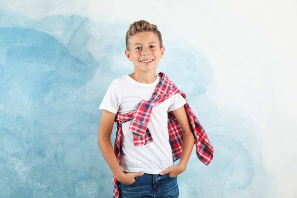 Niño en camiseta, jeans y camisa sobre fondo de color, espacio
  - Foto, imagen
