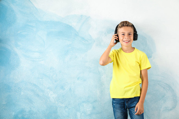 Niño con auriculares contra fondo de color, espacio para texto
 - Foto, imagen