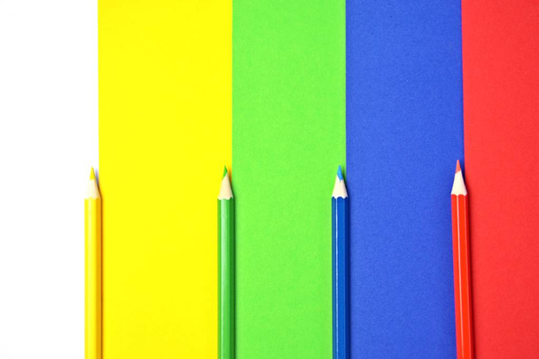 Quattro diversi pastelli colorati dividono un'area in quattro livelli, che a loro volta hanno il colore dei pastelli - un concetto con superficie divisa e matite colorate
  - Foto, immagini