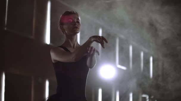 Prima balett cég egy sötét ruhában egy sötét színházi színpadon próbálni a füst végez táncmozgások lassítva - Felvétel, videó