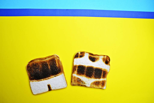 Trois toasts reposent sur un fond coloré - ceux-ci ne sont pas grillés sur toute la surface mais montrent les contours des troncs et du bikini et ceux d'un soleil - concept de coup de soleil présenté avec des toasts
  - Photo, image