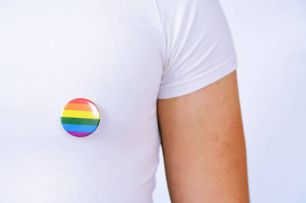 Een man in zijn mid-Twenties draagt een knop met het symbool voor transgender op zijn pak jas-concept voor acceptatie en tolerantie in het werk leven - Foto, afbeelding