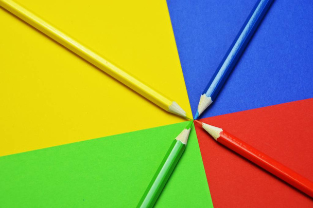 Четыре цветных карандаша делят площадь на четыре уровня, которые сами по себе имеют цвет карандаша - концепция с расщепленной поверхностью и цветными карандашами
  - Фото, изображение