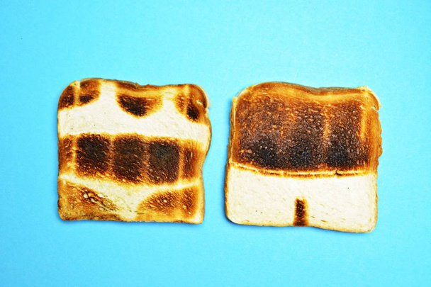 Drie toast liggen op een kleurrijke achtergrond-deze zijn niet geroosterd op het hele oppervlak, maar tonen de contouren van Trunks en bikini en die van een zon-concept van zonnebrand gepresenteerd met Toast  - Foto, afbeelding